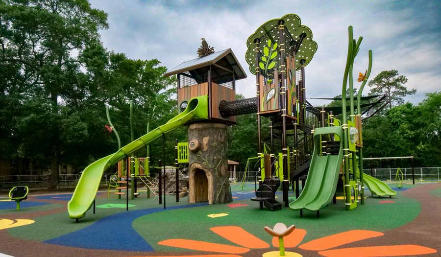 Nature-themed elementary school playground with slides and climbing structures